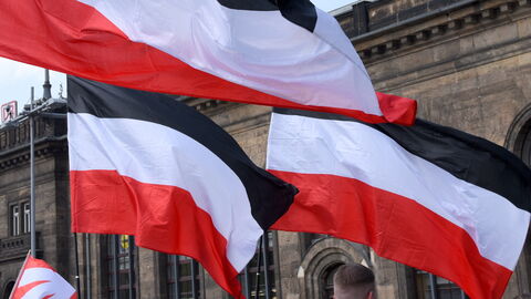 Symbolbild Rechtsextremismus Symbolbild für Rechtsextremismus. Zu sehen sind im Wind wehende schwarz-weiß-rote Fahnen bei einer Demonstration. Am unteren Bildrand sind auch Fahnen der rechtsextremistischen Partei NPD zu erkennen.