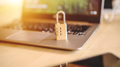 Auf der Abbildung sieht man ein Notebook auf dem ein Zahlenschloss steht - Sybolbild für Datenschutz 