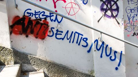 Graffiti-Schriftzug "Gegen Antisemitismus" auf einer Hauswand. Graffiti-Schriftzug "Gegen Antisemitismus" auf einer Hauswand. Der Wortteil "Anti" ist mit roter Farbe besprüht.