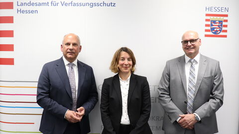 Innenminister Prof. Dr. Roman Poseck, PAAF-Leiterin Anika Schleinzer und LfV-Präsident Bernd Neumann vor einer Pressewand