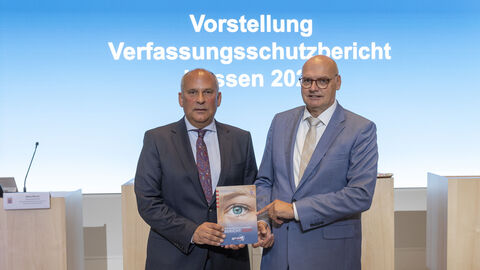 Innenminister Roman Poseck und der Präsident des LfV Hessen Bernd Neumann präsentieren den Jahresbericht 2024 des Landesamts für Verfassungsschutz Hessen Innenminister Roman Poseck und der Präsident des LfV Hessen Bernd Neumann präsentieren den Jahresbericht 2024 des Landesamts für Verfassungsschutz Hessen und halten ein Exemplar in die Kamera